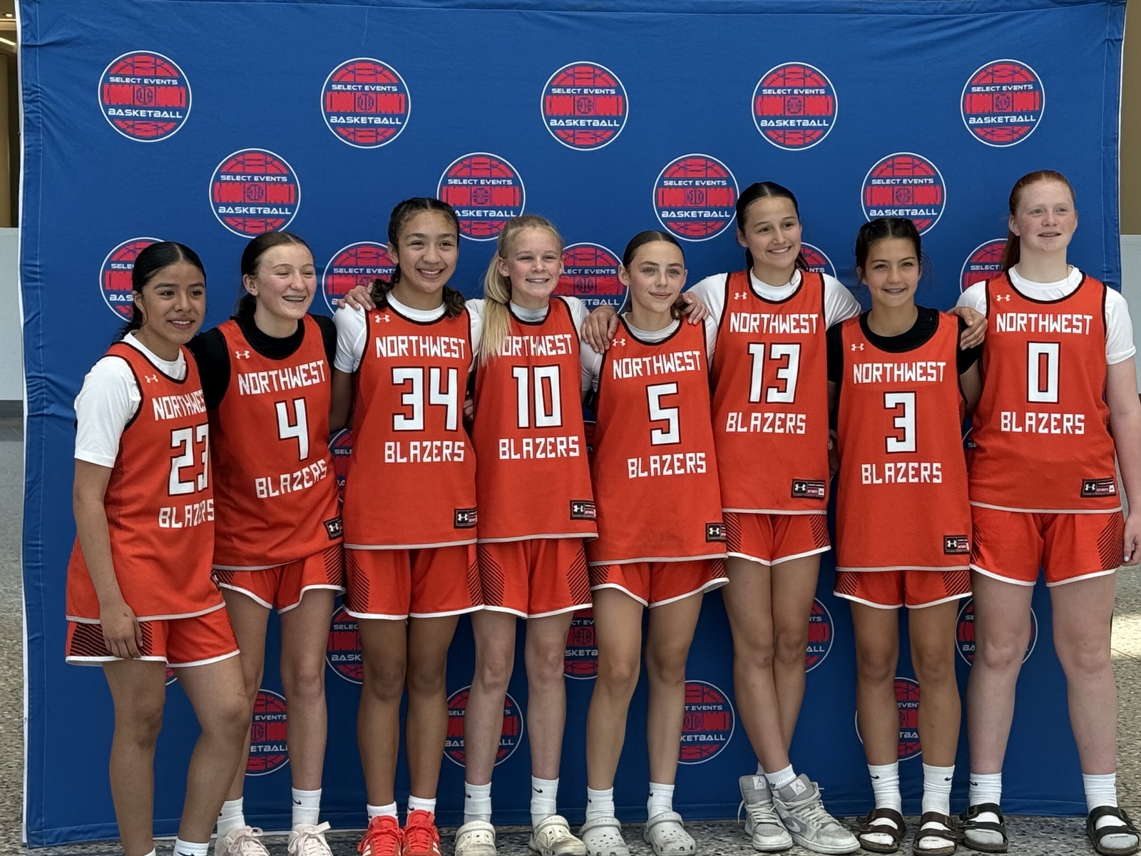 Northwest Blazers lineup in front of Select Events blue media wall.