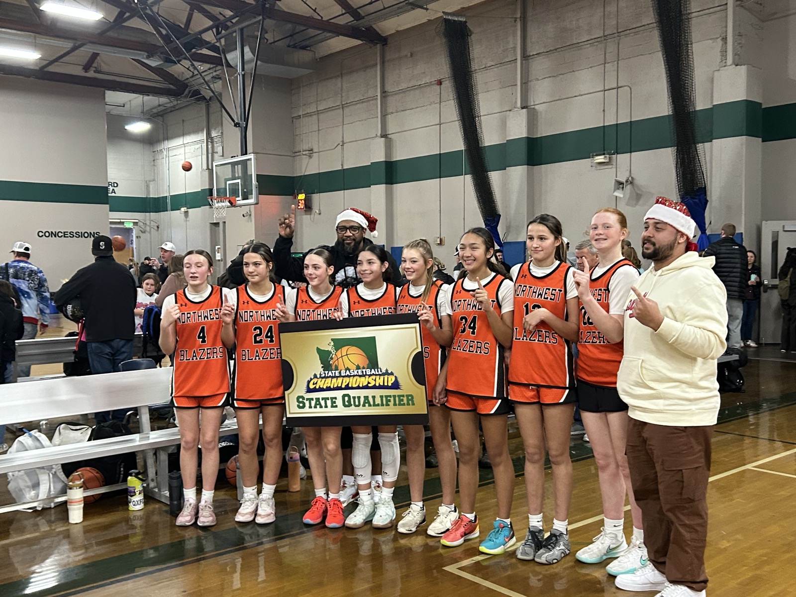 Northwest Blazers state qualifier celebration photo in gym during holiday event.